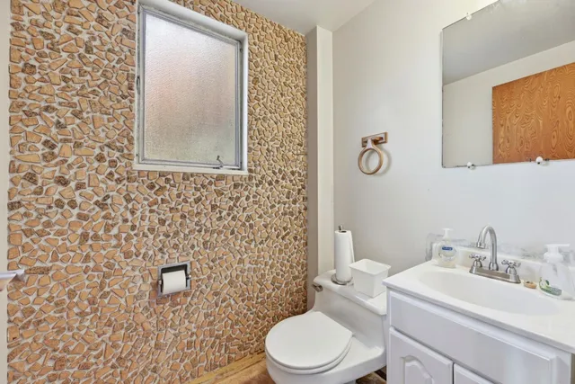 a bathroom with a toilet a sink and mirror