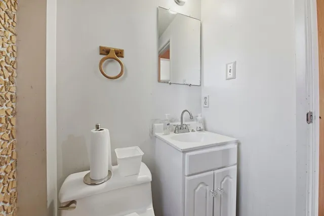 a bathroom with a toilet sink and mirror