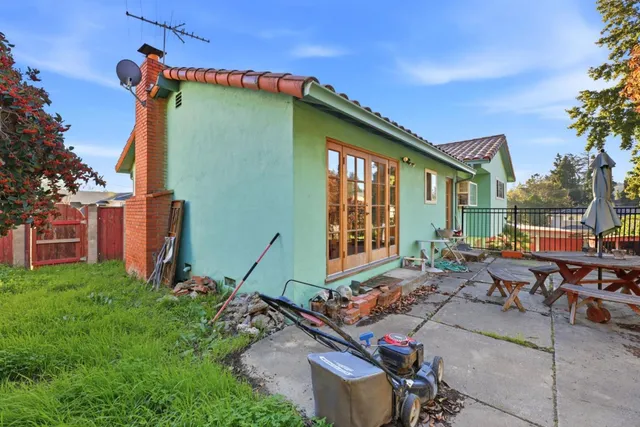 a backyard of a house with barbeque oven table and chairs