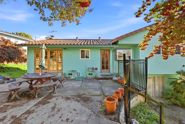 a backyard of a house with barbeque oven table and chairs