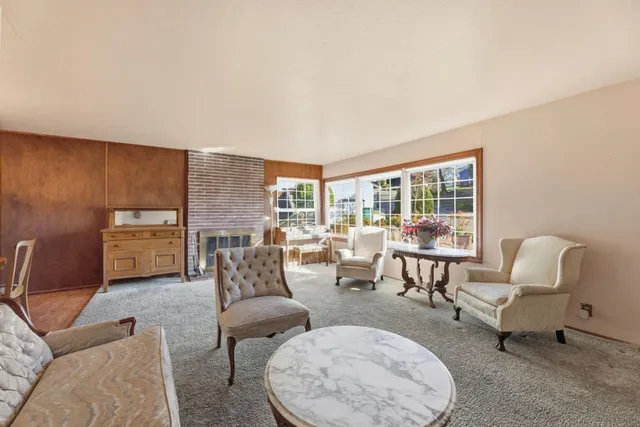 a living room with furniture and a floor to ceiling window