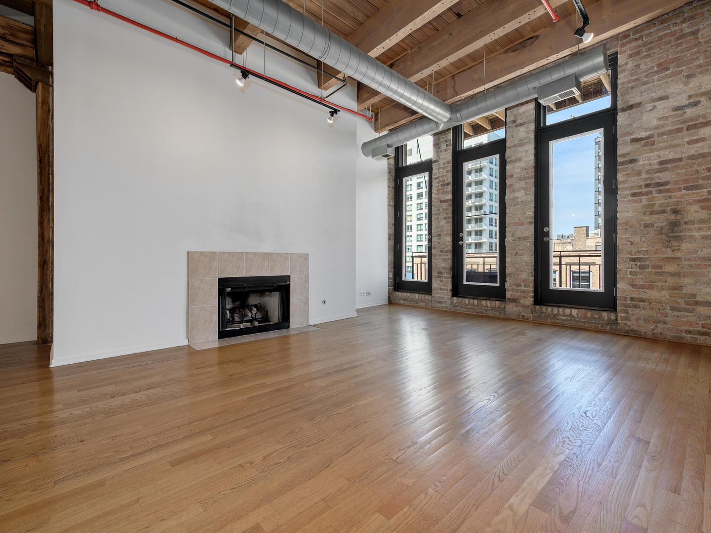 375 West Erie Street, Unit 508 Chicago, IL 60654 - Photo 3 of 16 an empty room with wooden floor and fireplace