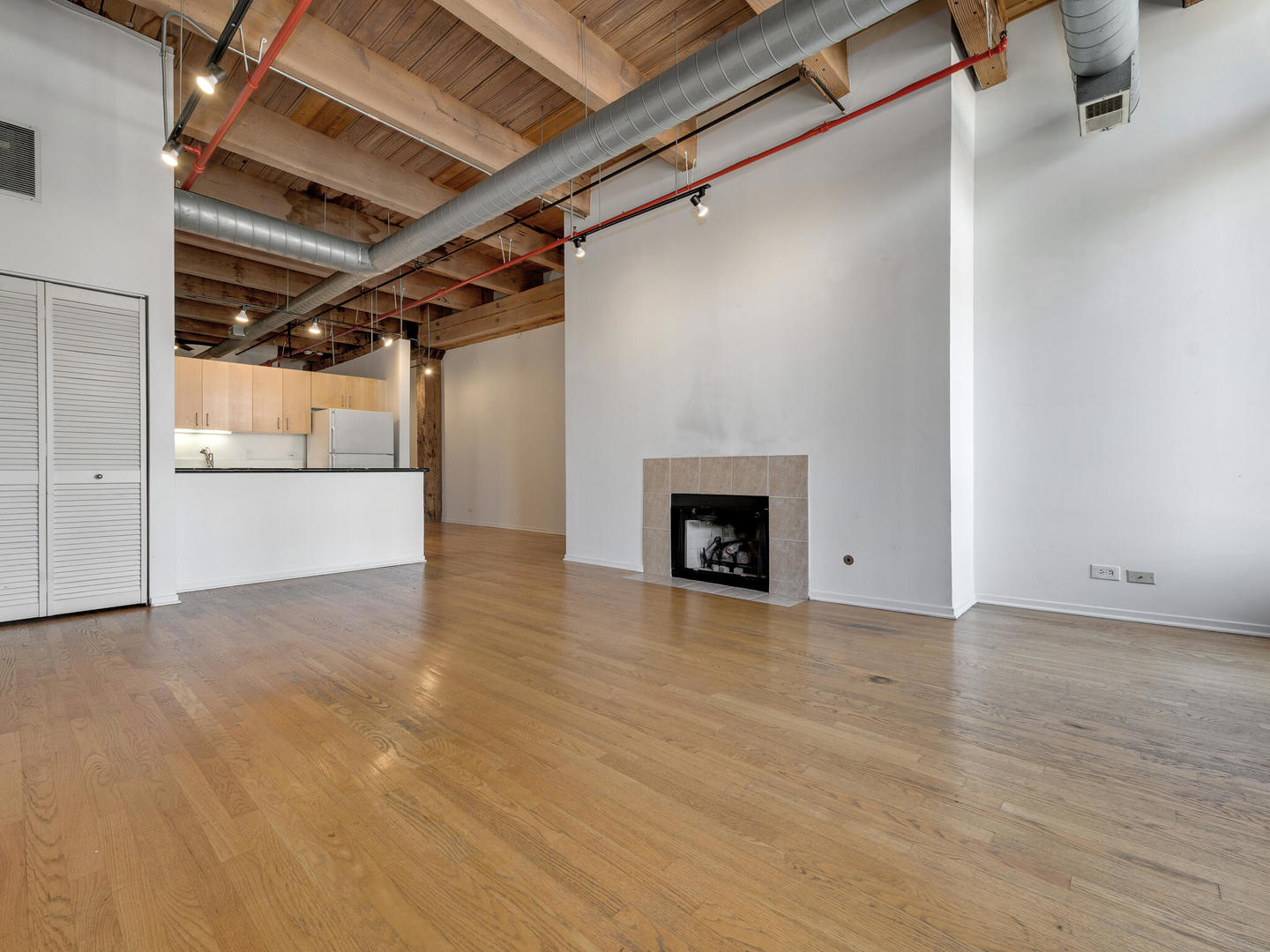 375 West Erie Street, Unit 508 Chicago, IL 60654 - Photo 4 of 16 a view of empty room with wooden floor and fireplace