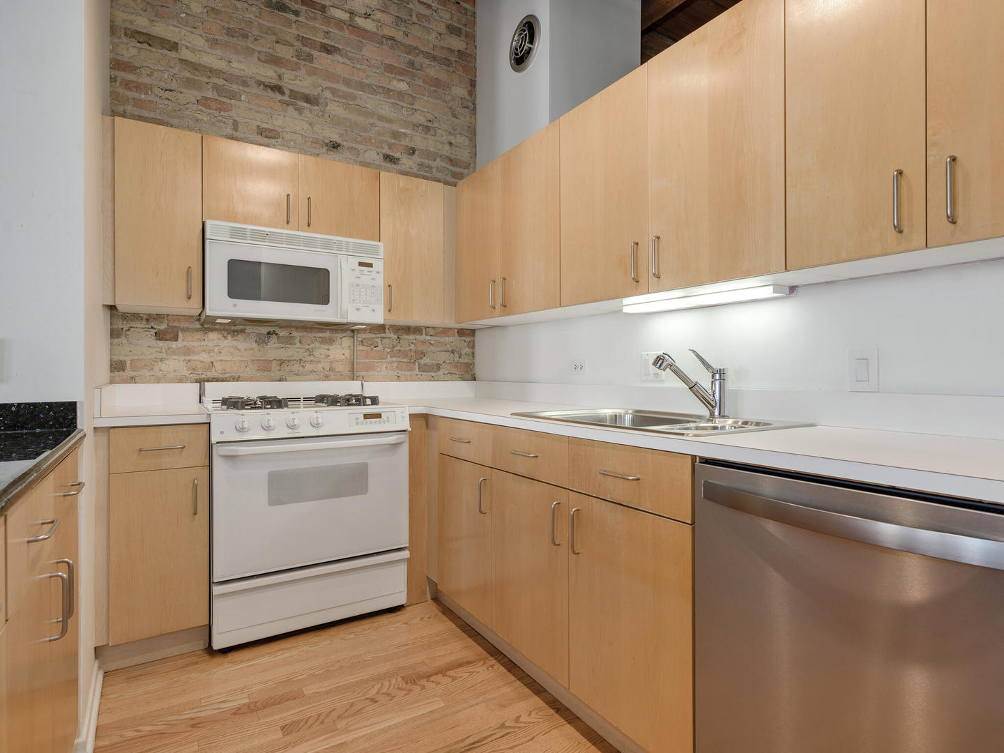 375 West Erie Street, Unit 508 Chicago, IL 60654 - Photo 9 of 16 a kitchen with granite countertop white cabinets sink and stainless steel appliances