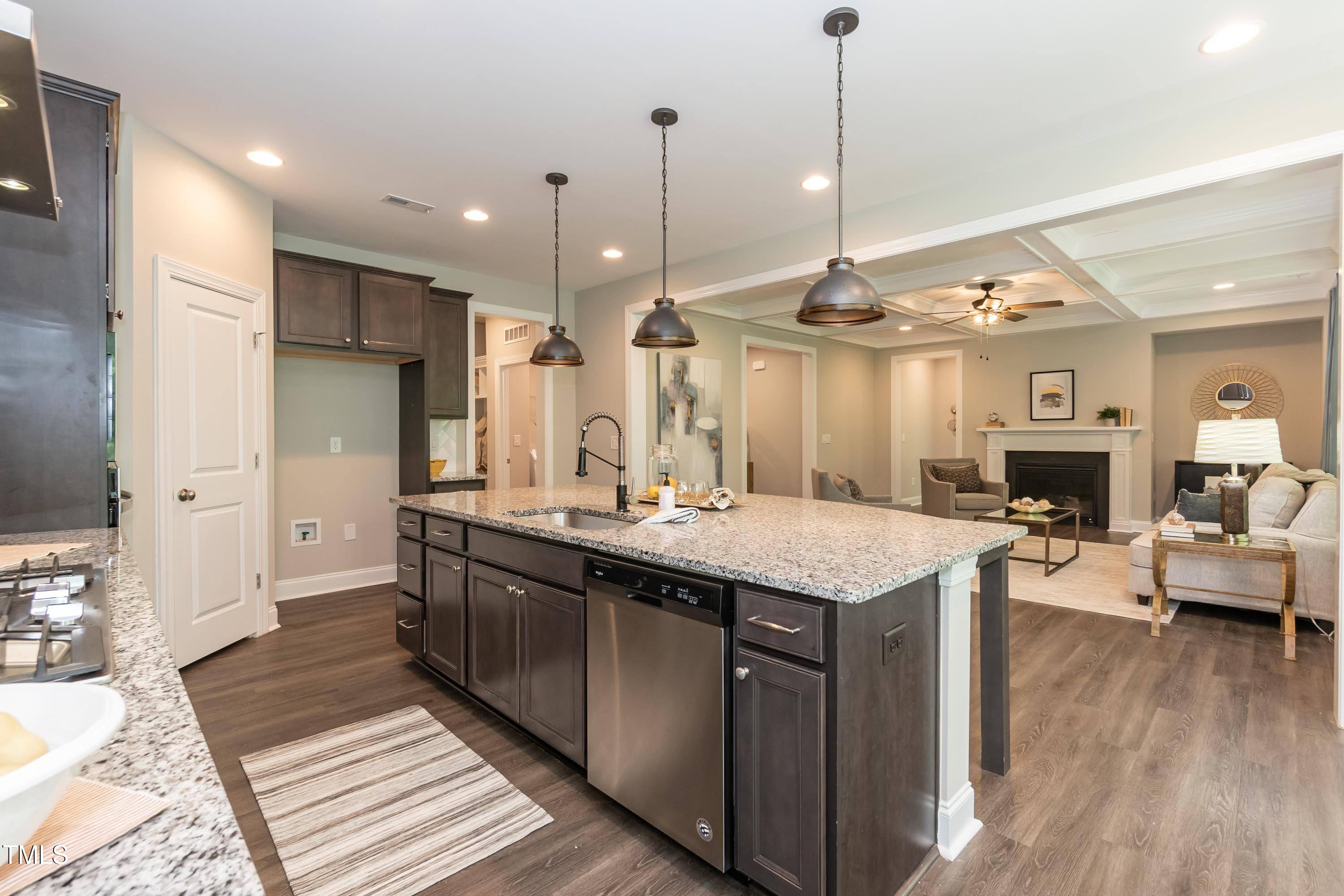 273 Scarlet Tanager Circle Holly Springs, NC 27540 - Photo 12 of 35 a kitchen with kitchen island granite countertop a sink appliances and wooden floor