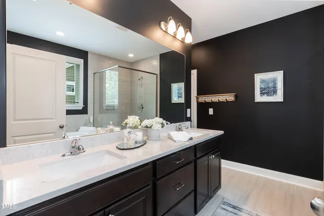 a bathroom with a sink double vanity granite and a mirror
