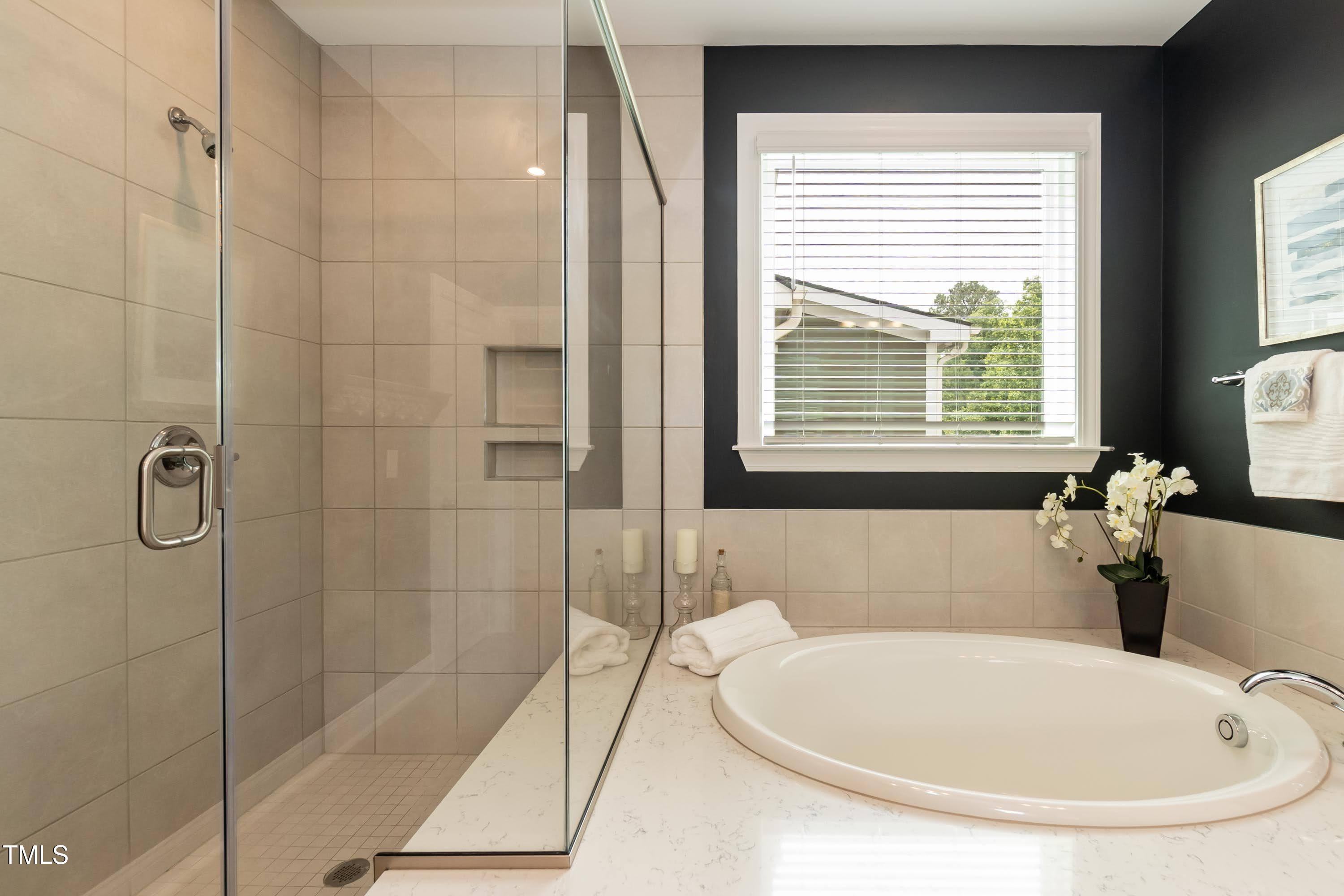 273 Scarlet Tanager Circle Holly Springs, NC 27540 - Photo 20 of 35 a bathroom with a tub a window and a shower