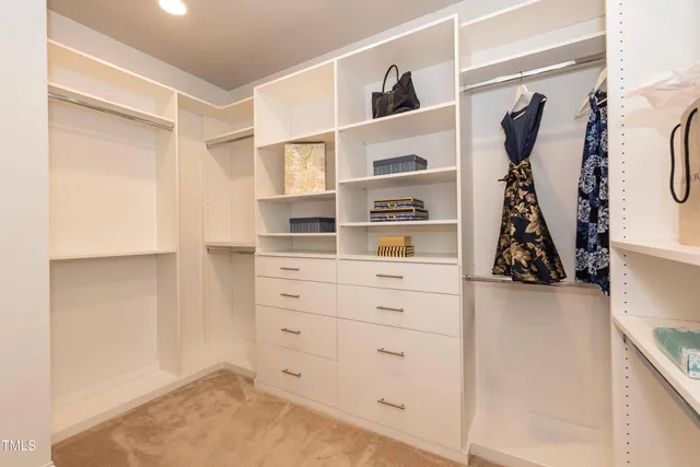 a view of walk in closet with clothes