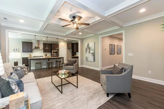 a living room with furniture kitchen view and a chandelier