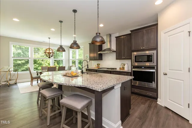 a kitchen with kitchen island granite countertop wooden floor and stainless steel appliances