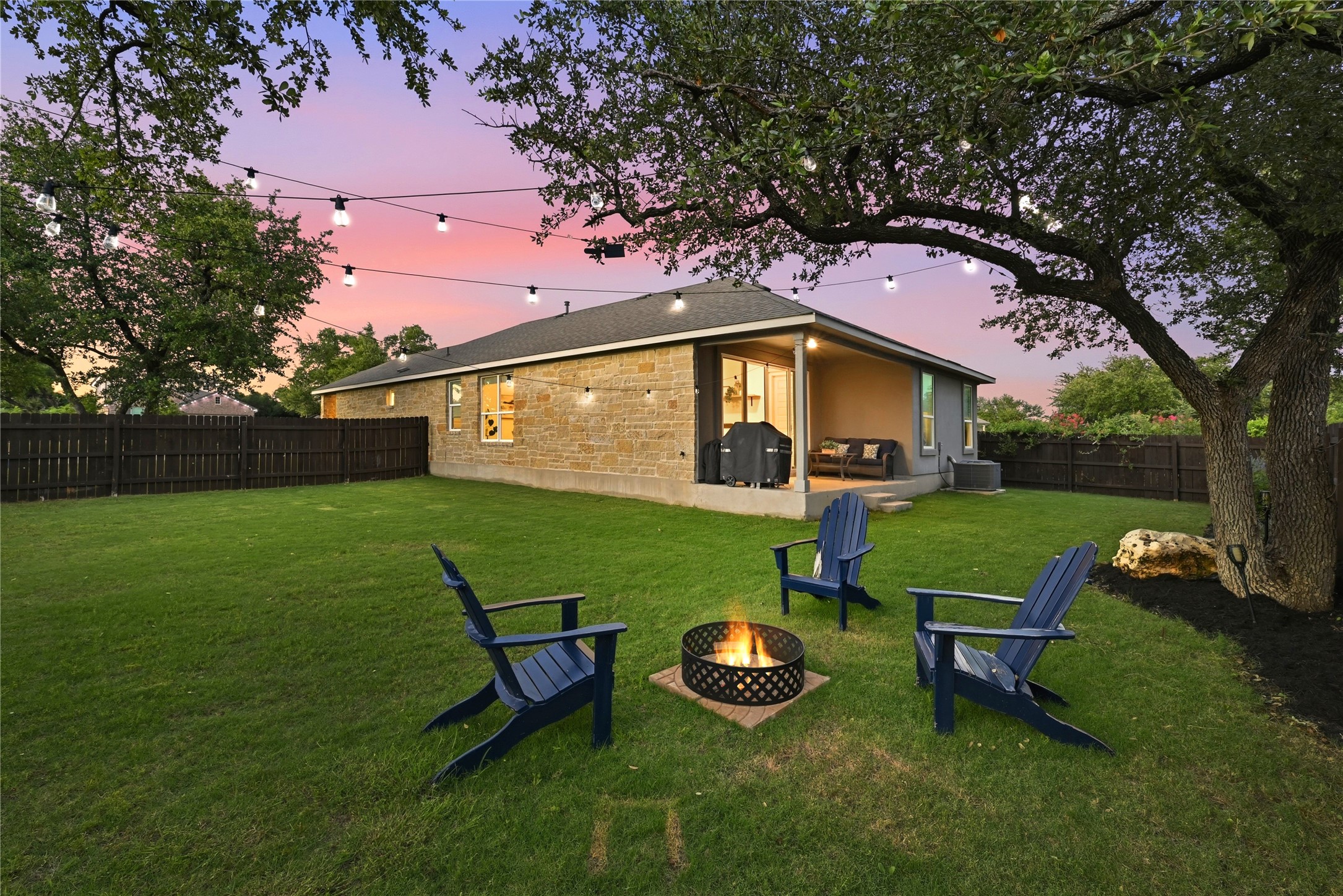 4420 Ingram Road Georgetown, TX 78628 - Photo 29 of 40 Relax in this fenced backyard oasis, featuring a fire pit and a covered patio perfect for evening gatherings.