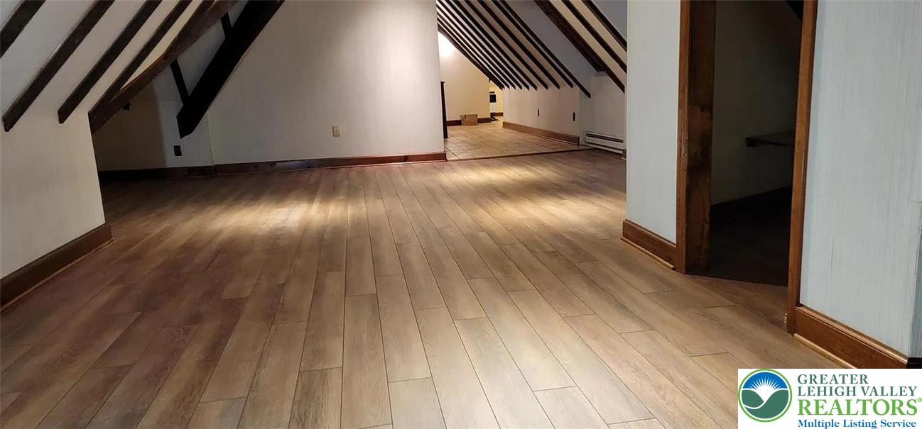 444 West 3rd Street, Unit 9 Bethlehem, PA 18015 - Photo 13 of 16 Exposed ceiling beams complement the wooden plank flooring, defining this versatile attic space.