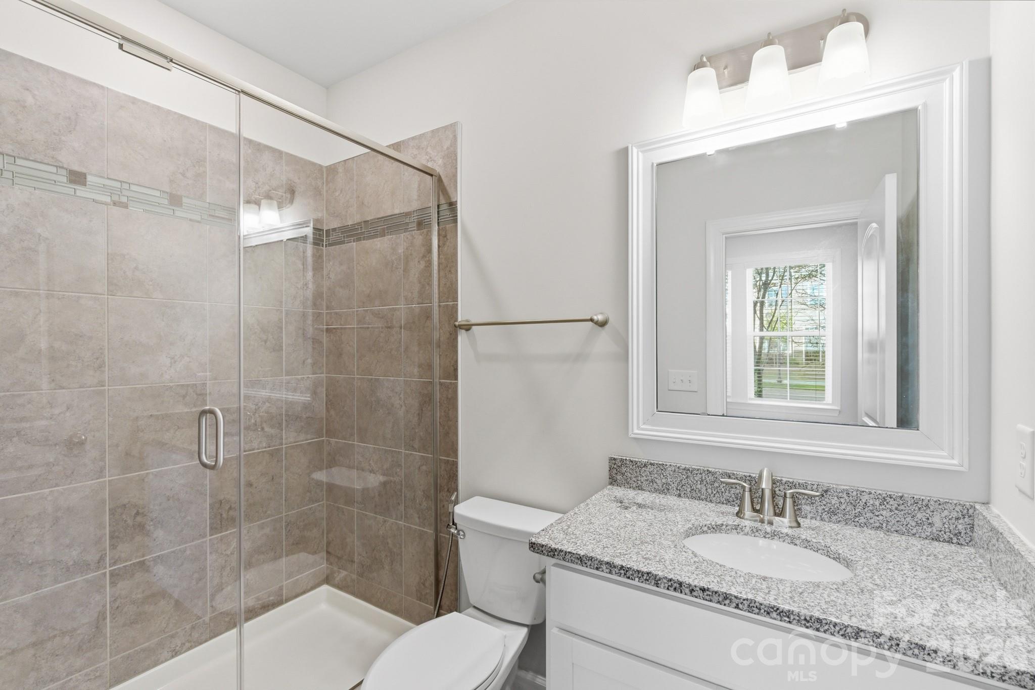 11515 Red Rust Lane Charlotte, NC 28277 - Photo 12 of 48 a bathroom with a granite countertop sink a toilet and shower
