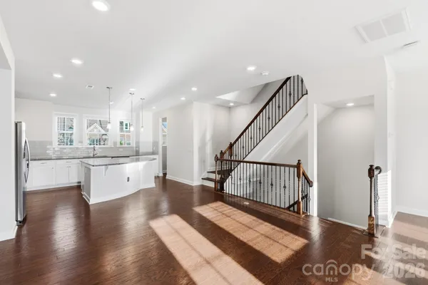 a large kitchen with stainless steel appliances kitchen island granite countertop a refrigerator and a sink