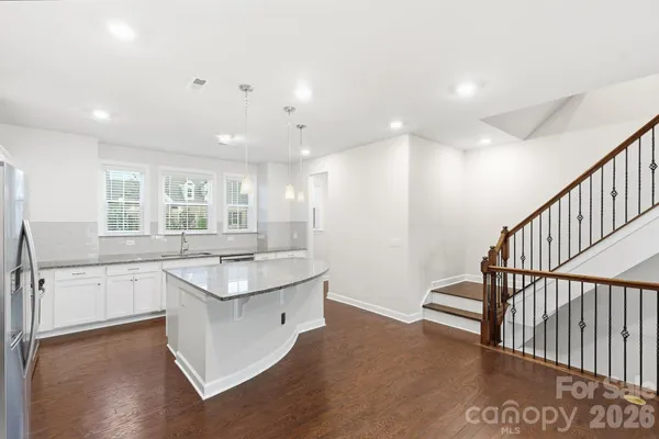 a kitchen with granite countertop a refrigerator sink and cabinets