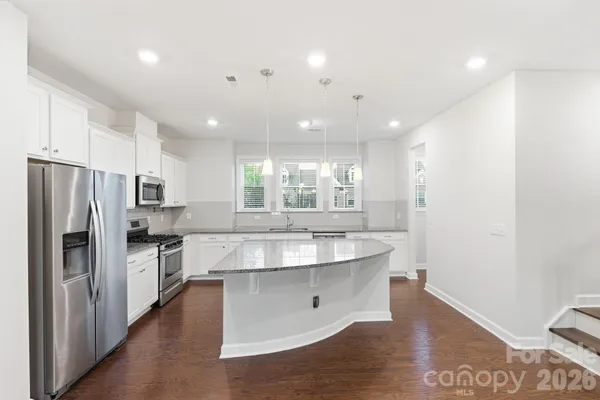 a kitchen with kitchen island a counter top space appliances and cabinets