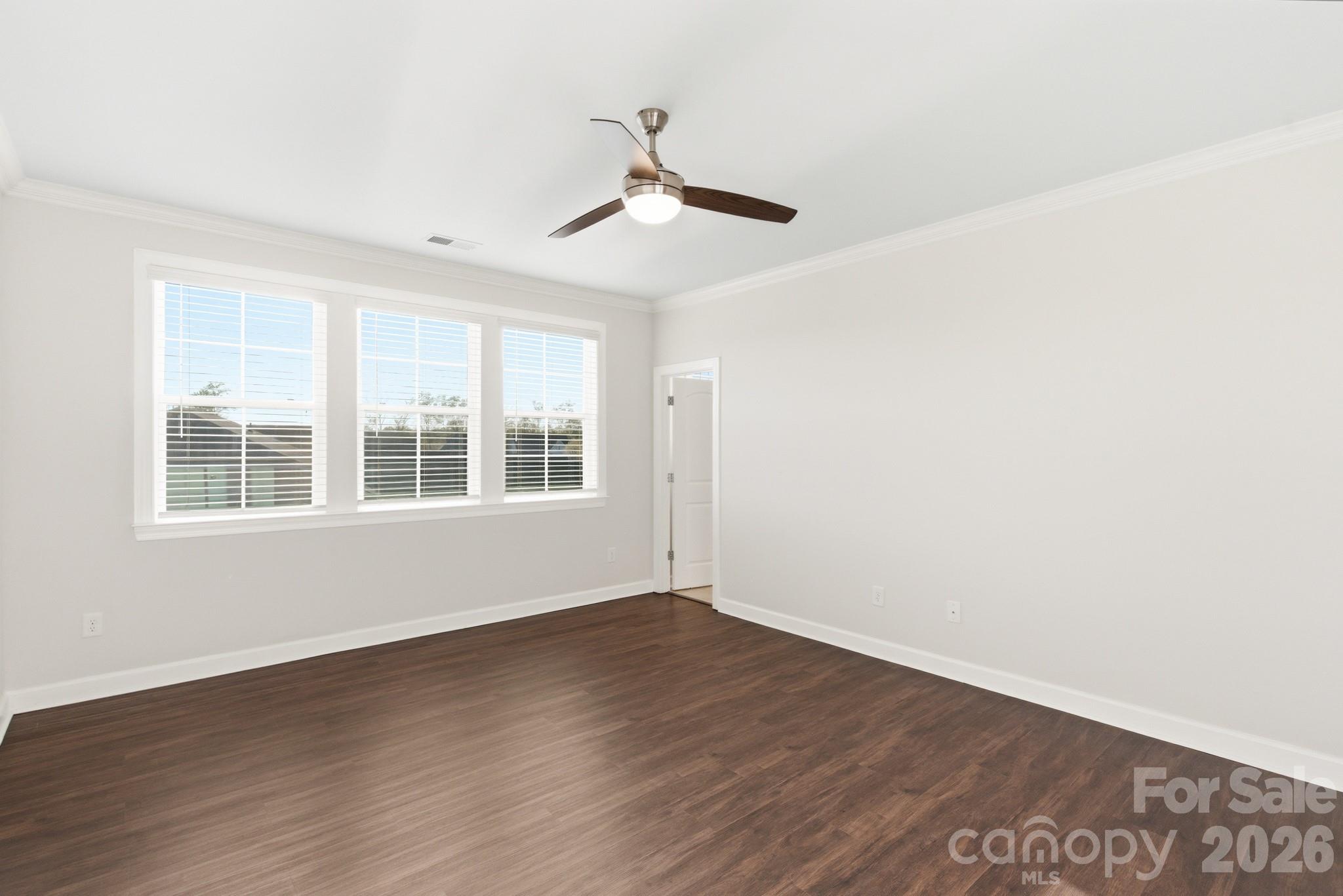 11515 Red Rust Lane Charlotte, NC 28277 - Photo 30 of 48 an empty room with wooden floor ceiling fan and windows