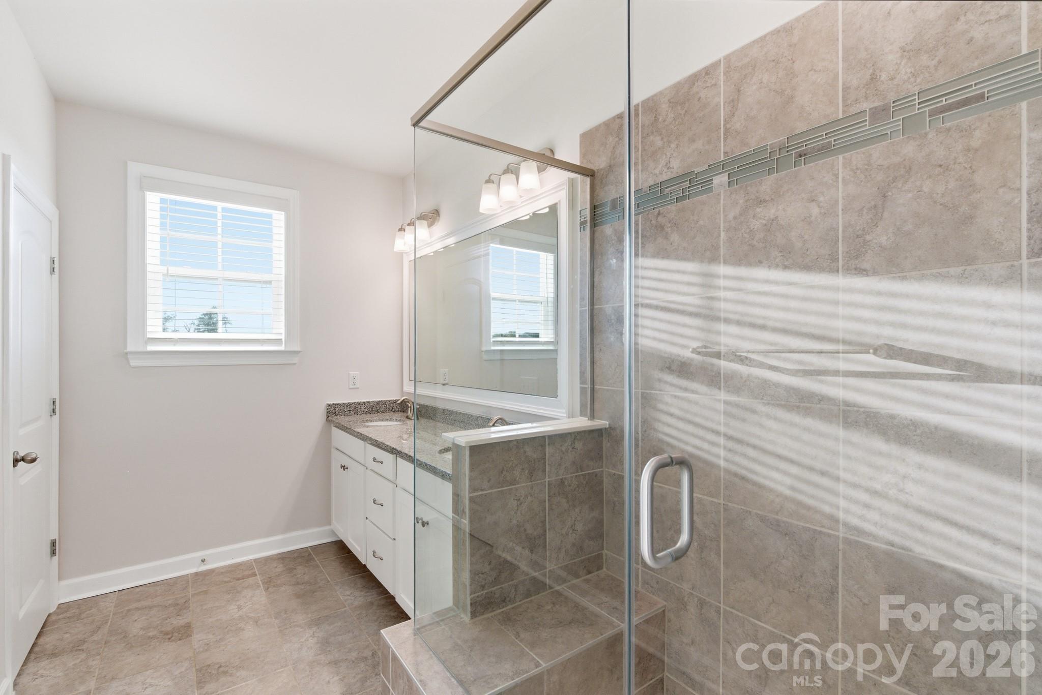11515 Red Rust Lane Charlotte, NC 28277 - Photo 33 of 48 a bathroom with a granite countertop sink a mirror and a shower
