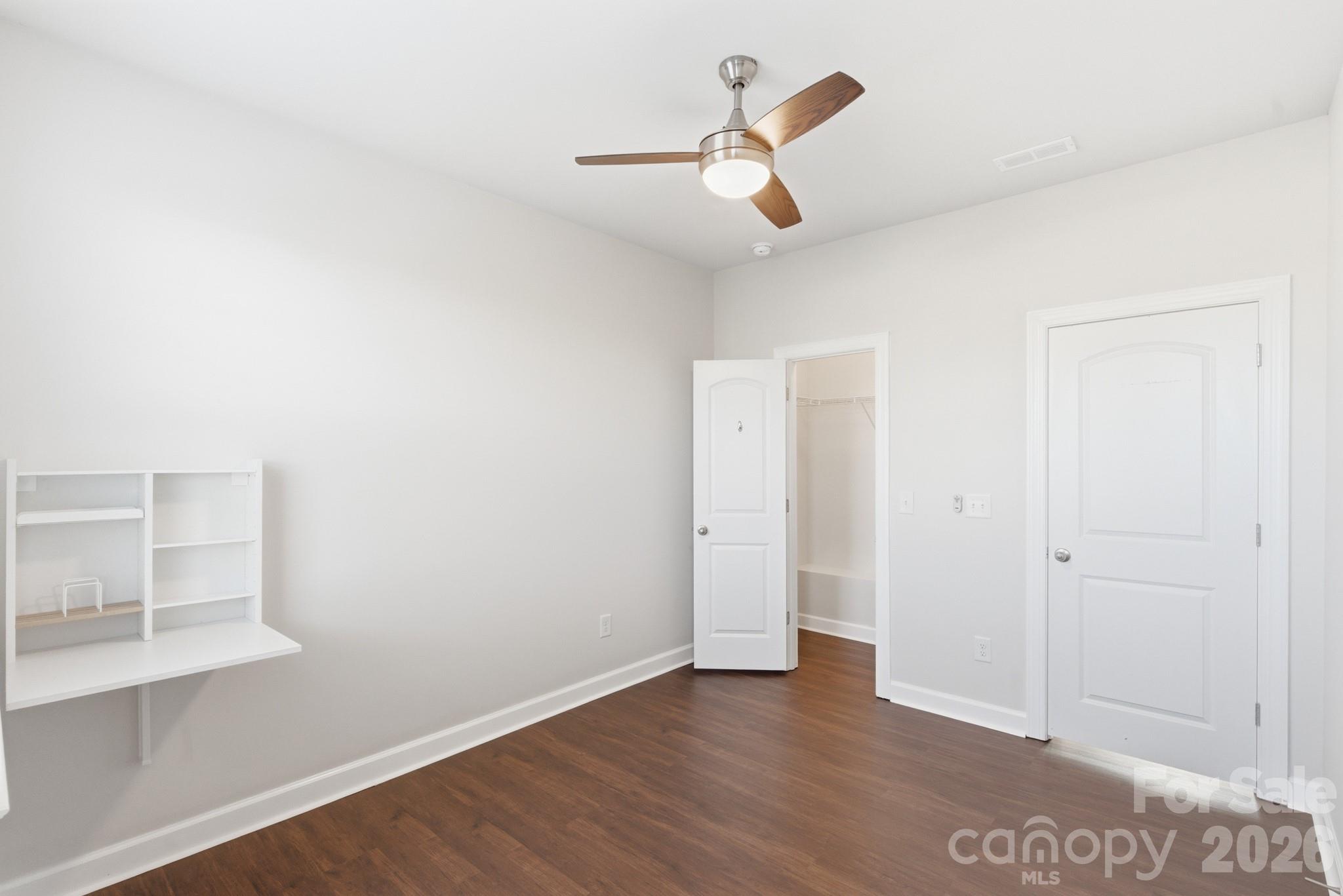 11515 Red Rust Lane Charlotte, NC 28277 - Photo 38 of 48 an empty room with wooden floor chandelier fan and windows