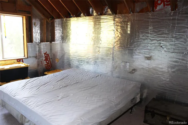 a bed sitting in a bedroom next to a window