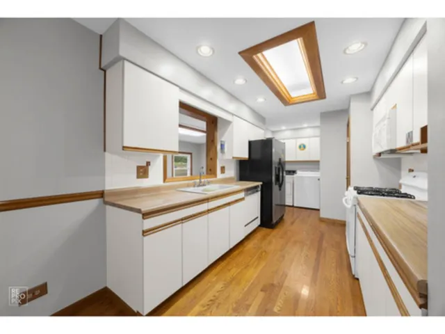 a large kitchen with stainless steel appliances kitchen island granite countertop a large counter top and a stove