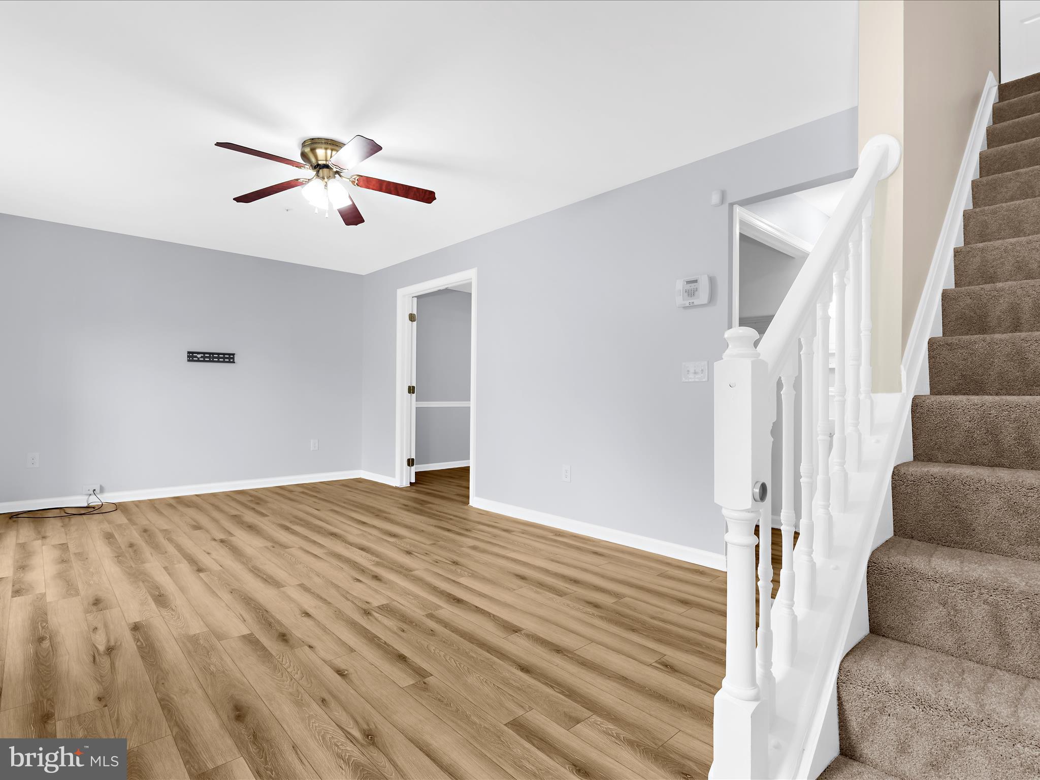 116 Langdon Farm Circle Odenton, MD 21113 - Photo 3 of 60 a view of an empty room with wooden floor and a ceiling fan