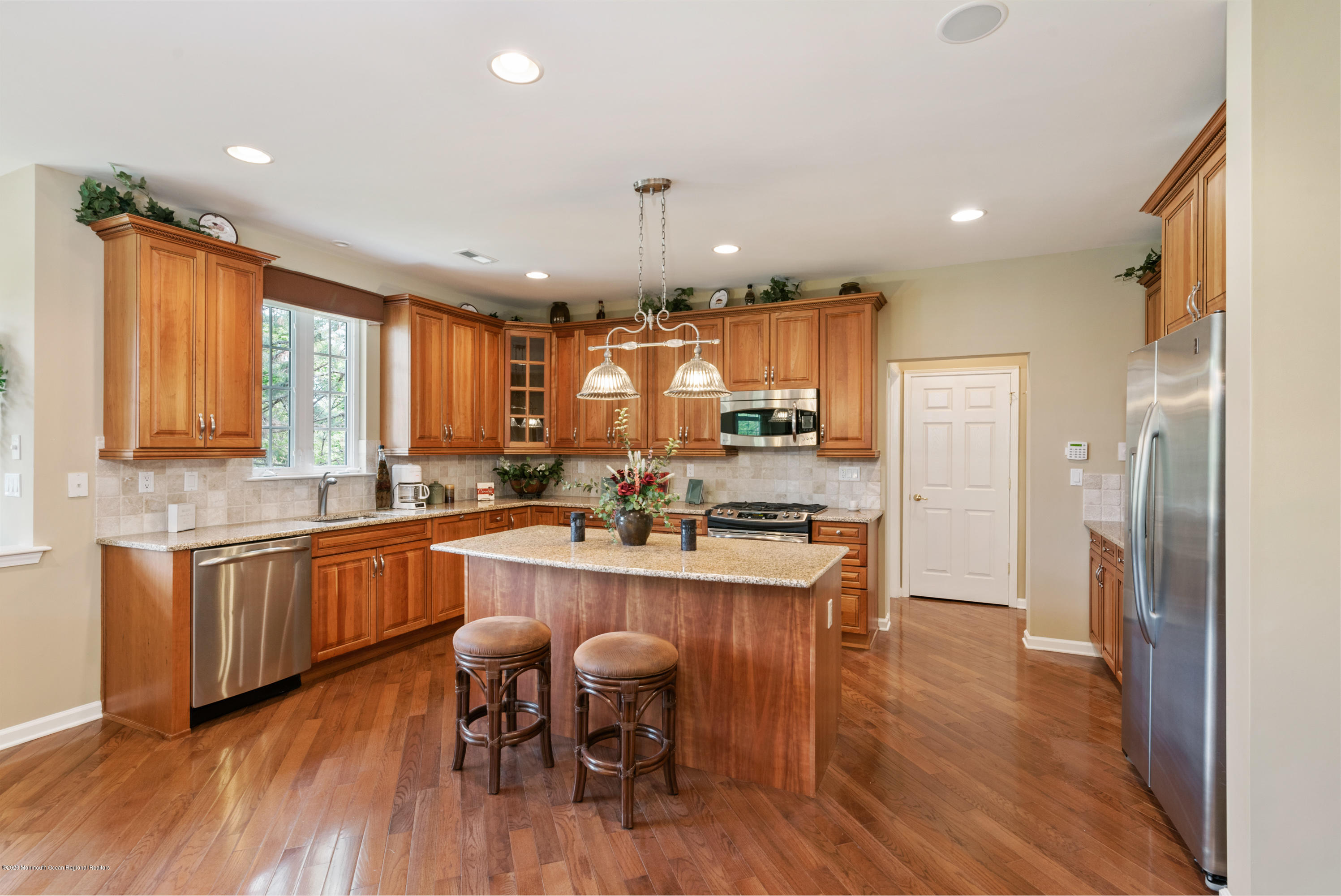 1 Bellagio Road Jackson, NJ 08527 - Photo 7 of 48 a kitchen with stainless steel appliances granite countertop a refrigerator a sink dishwasher a stove and a dining table with wooden floor