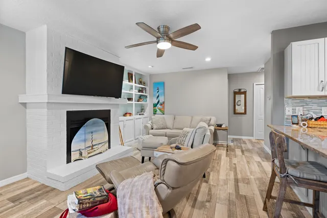 a kitchen with stainless steel appliances granite countertop a stove top oven a sink dishwasher a dining table and chairs with wooden floor