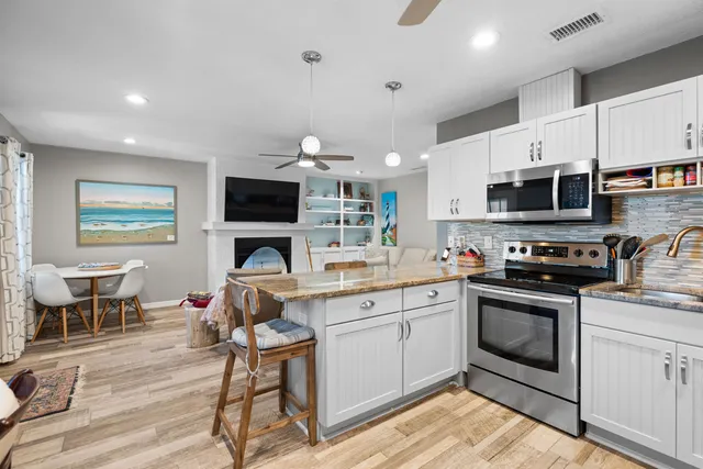a kitchen with kitchen island white cabinets and stainless steel appliances