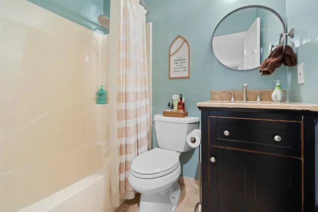 a spacious bedroom with a bed and a chandelier