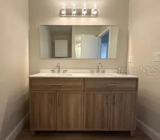 a bathroom with a sink vanity and a mirror