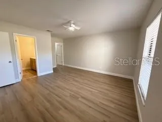 an empty room with wooden floor and windows