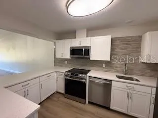 a kitchen with cabinets stainless steel appliances and a sink