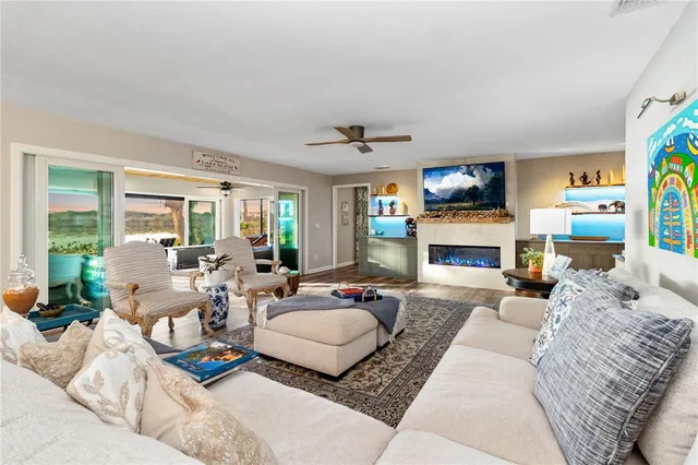 a living room with furniture a fireplace and a flat screen tv