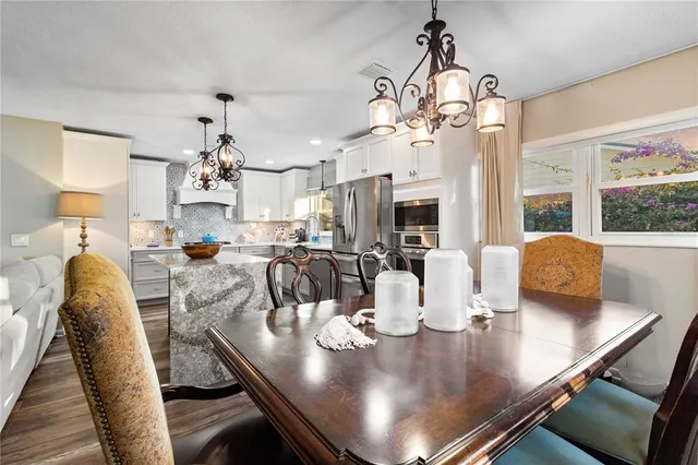a view of a dining room with furniture a chandelier and wooden floor