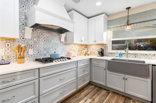 a kitchen with stainless steel appliances a stove and white cabinets