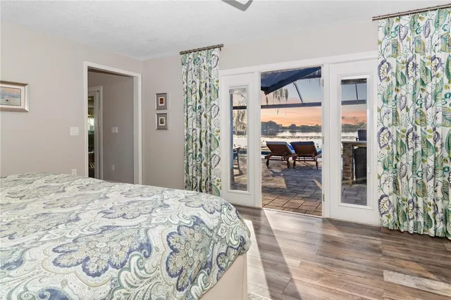 a bedroom with a large bed and a wooden floor