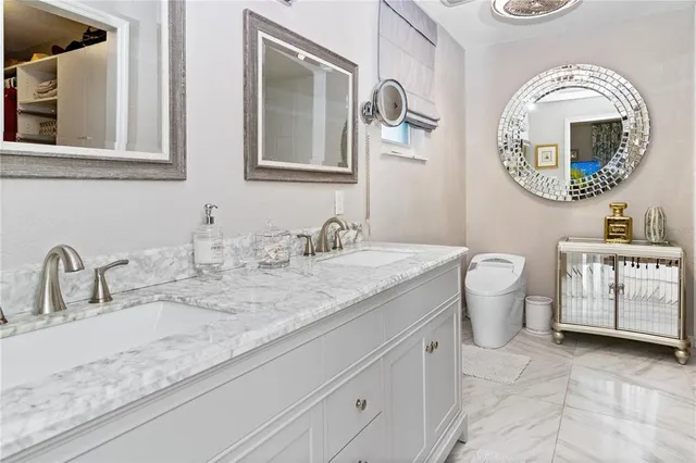 a bathroom with a granite countertop toilet a sink and a mirror