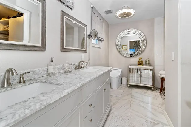 a bathroom with a granite countertop toilet a sink and a mirror