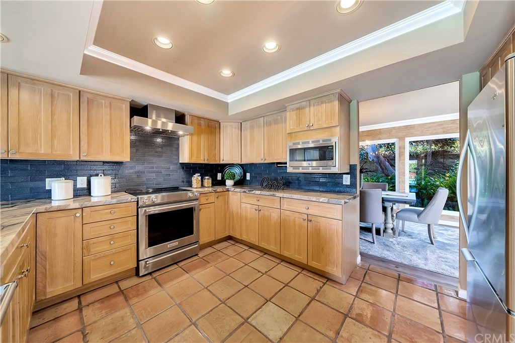 23802 Cassandra Bay Dana Point, CA 92629 - Photo 20 of 48 a kitchen with granite countertop cabinets a stove a sink and a dining table view