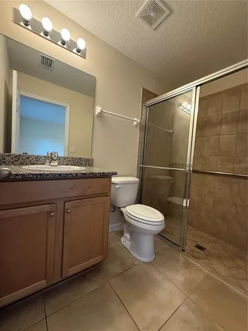 a bathroom with a granite countertop sink toilet and mirror