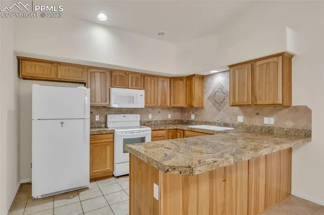 a kitchen with a sink a stove a refrigerator and cabinets
