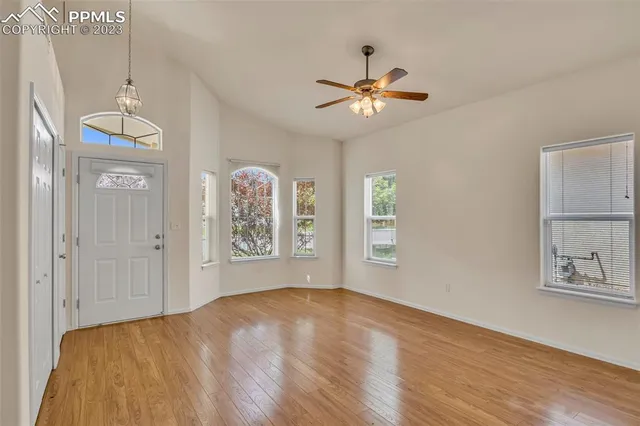 a view of empty room with window and wooden floor