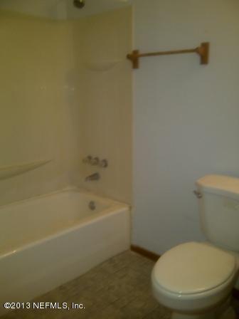 5009 Spring Glen Road Jacksonville, FL 32207 - Photo 10 of 16 a white toilet sitting next to a bath tub