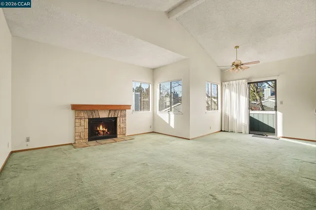 an empty room with a fireplace and window