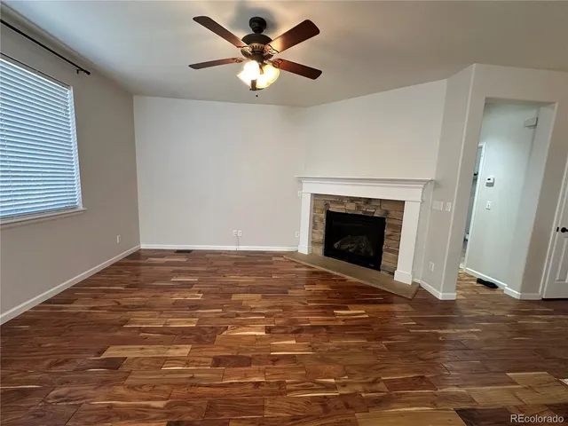 an empty room with fan and fireplace