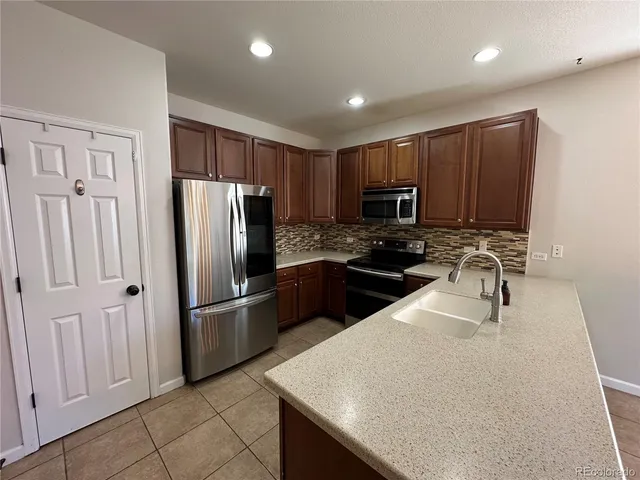 a kitchen with granite countertop a refrigerator and a sink