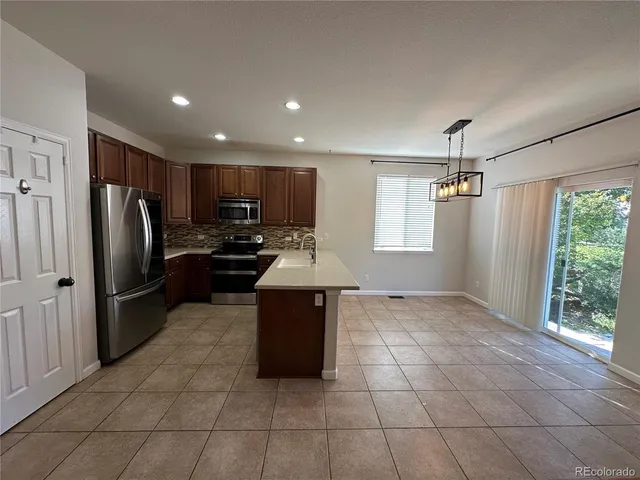 a kitchen with granite countertop a refrigerator and a sink