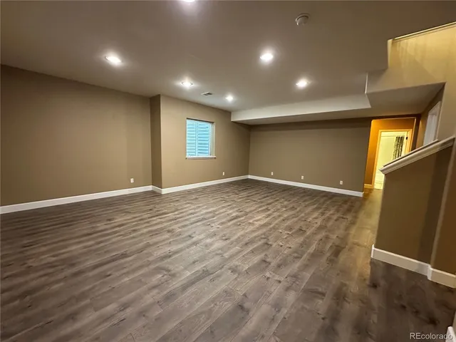 an empty room with wooden floor and entrance