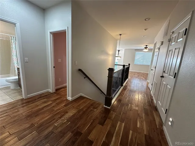a view of a hallway with wooden floor and staircase